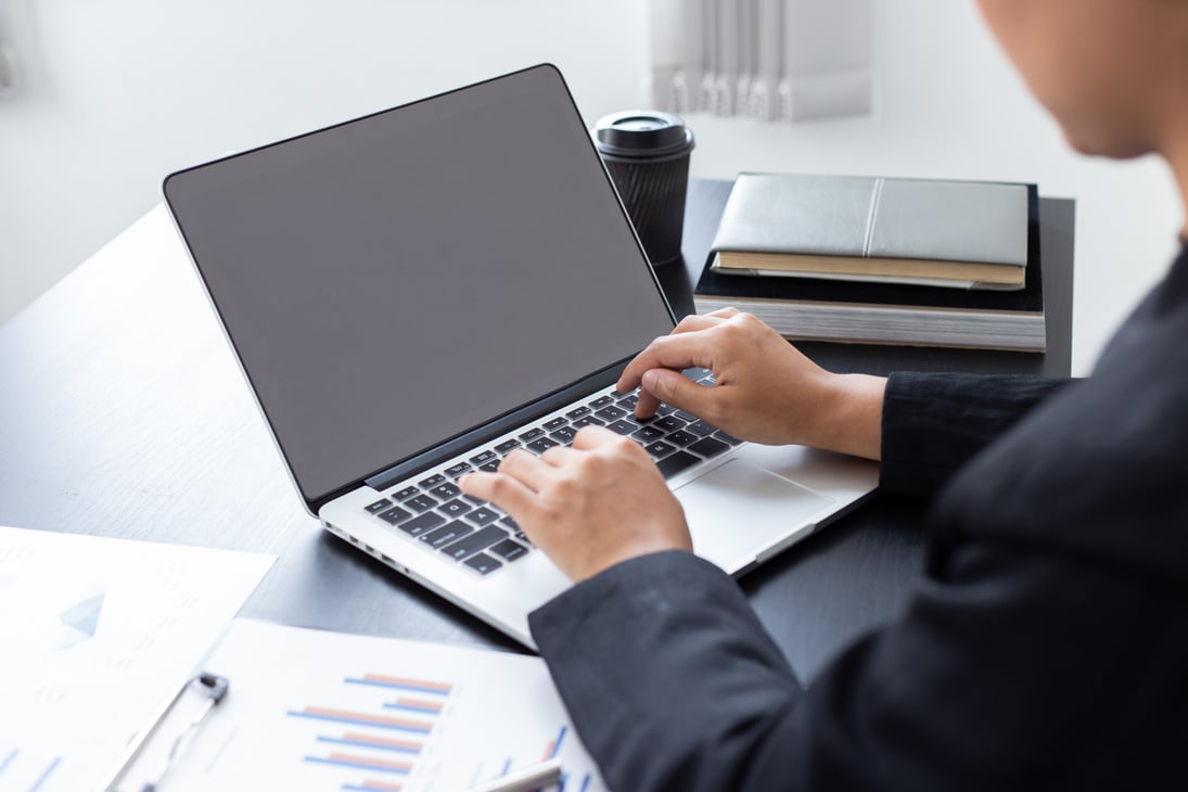 A Businessman Typing on a Laptop